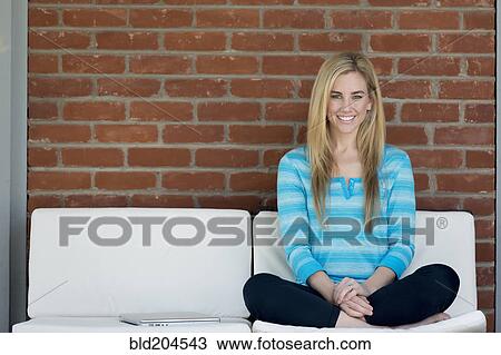 Stock Image - Caucasian woman sitting outdoors. Fotosearch