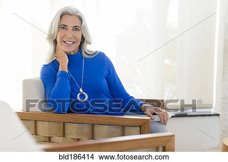 Picture - Caucasian woman smiling in armchair. Fotosearch