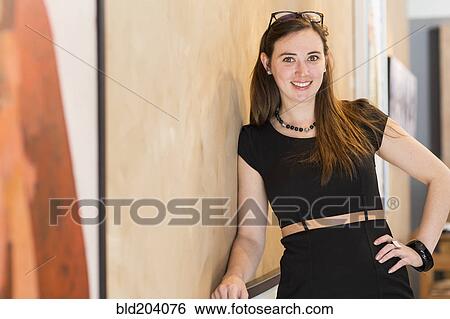 Stock Photograph - Caucasian woman smiling in art gallery. Fotosearch
