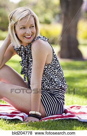 Caucasian woman smiling in grass View Large Photo Image Stock Photo - Caucasian woman smiling in grass. Fotosearch