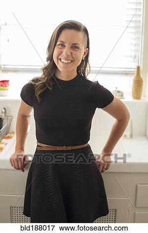 Caucasian woman smiling in kitchen View Large Photo Image Stock Photo - Caucasian woman smiling in kitchen. Fotosearch