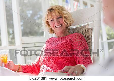 Caucasian woman smiling on porch View Large Photo Image Stock Image - Caucasian woman smiling on porch. Fotosearch