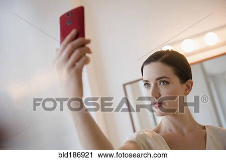 Stock Image - Caucasian woman taking selfie. Fotosearch