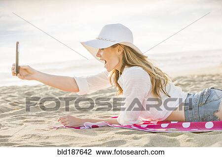 Caucasian woman using cell phone on beach View Large Photo Image Stock Image - Caucasian woman using cell phone on beach. Fotosearch