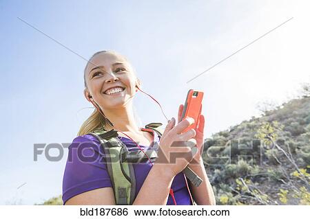 Stock Photograph - Caucasian woman using cell phone outdoors. Fotosearch