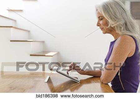 Stock Photo - Caucasian woman using digital tablet. Fotosearch