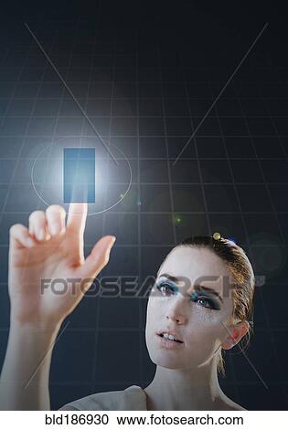 Stock Image - Caucasian woman using holographic touch screen. Fotosearch