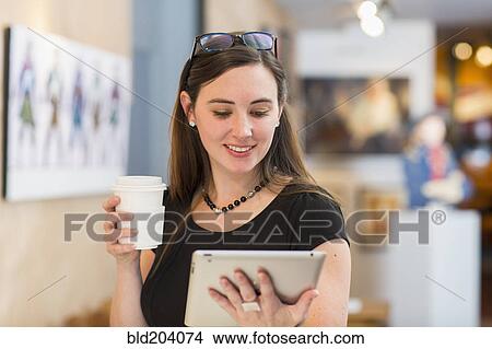 Caucasian woman using tablet computer in art gallery View Large Photo Image Picture - Caucasian woman using tablet computer in art gallery. Fotosearch