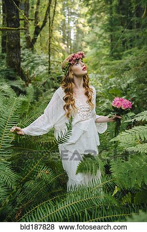 Stock Photo - Caucasian woman wearing flower crown in forest. Fotosearch