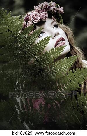 Stock Photo - Caucasian woman wearing flower crown in forest. Fotosearch