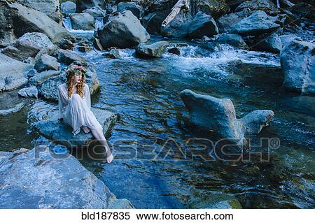 Caucasian woman wearing flower crown on rock at river View Large Photo Image Stock Photography - Caucasian woman wearing flower crown on rock at river. Fotosearch