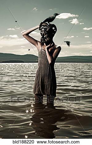 Stock Image - Caucasian woman wearing mask in lake. Fotosearch