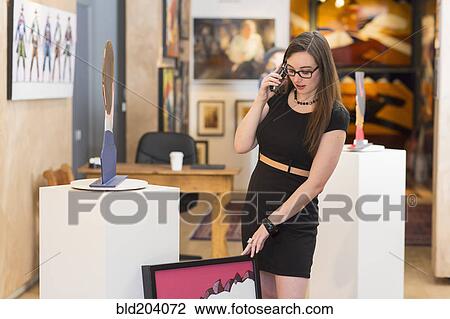 Stock Image - Caucasian woman working in art gallery. Fotosearch