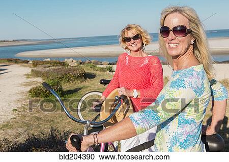 Caucasian women riding bicycles together View Large Photo Image Stock Image - Caucasian women riding bicycles together. Fotosearch