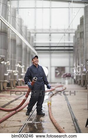 Chilean man holding industrial hose at winery View Large Photo Image Stock Photograph - Chilean man holding industrial hose at winery. Fotosearch