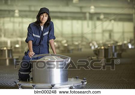 Stock Photo - Chilean woman standing near vat at winery. Fotosearch