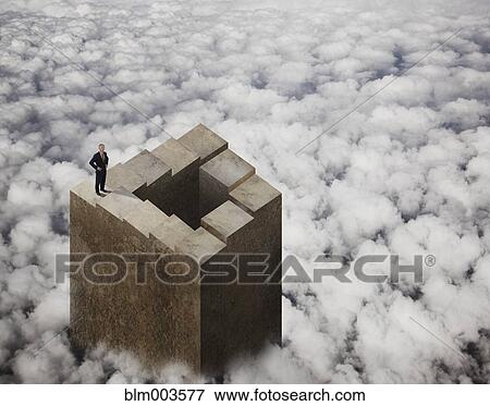 Stock Photo - Chinese businessman standing on tower above clouds. Fotosearch