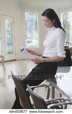 Stock Photo - Chinese businesswoman reviewing document in office. Fotosearch