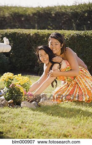 Stock Photo - Chinese daughter hugging mother in garden. Fotosearch