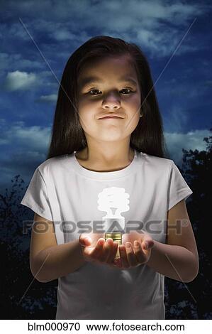Stock Image - Chinese girl holding glowing cfl lightbulb. Fotosearch