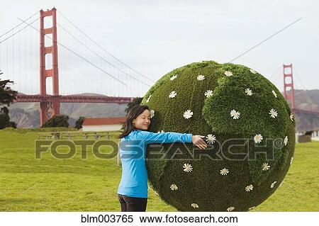 Stock Photography - Chinese girl hugging earth topiary. Fotosearch