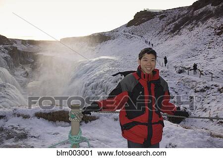 Stock Image - Chinese man standing on remote ice field. Fotosearch