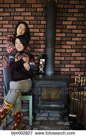 Chinese mother and daughter hugging near fireplace View Large Photo Image Stock Photo - Chinese mother and daughter hugging near fireplace. Fotosearch