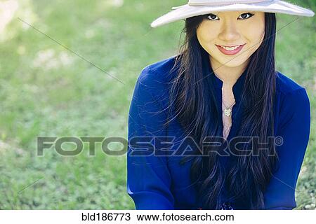 Stock Image - Chinese woman smiling outdoors. Fotosearch