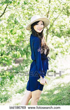 Stock Photo - Chinese woman standing in garden. Fotosearch