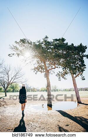 Stock Photo - Chinese woman walking in field. Fotosearch