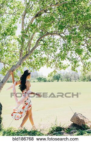 Chinese woman walking near pond View Large Photo Image Stock Photo - Chinese woman walking near pond. Fotosearch
