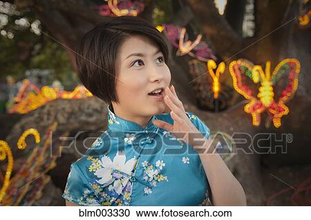 Stock Image - Chinese woman watching Chinese New Year's festival. Fotosearch