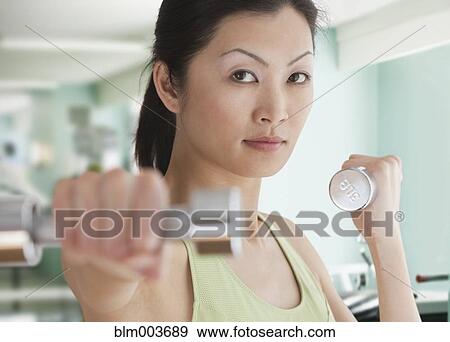 Stock Photo - Chinese woman working out with hand weights. Fotosearch