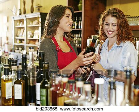 Stock Photography - Clerk helping customer in grocery store. Fotosearch