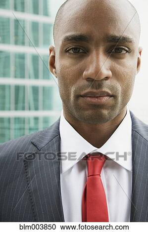 Stock Image - Close up of African businessman looking serious. Fotosearch