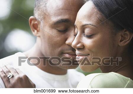 Stock Photo - Close up of African couple hugging outdoors. Fotosearch