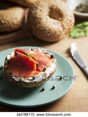 Stock Image - Close up of bagel with cream cheese and lox. Fotosearch