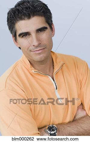 Stock Image - Close up of Cuban man with arms crossed. Fotosearch