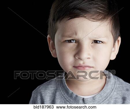 Stock Image - Close up of Hispanic boy frowning. Fotosearch