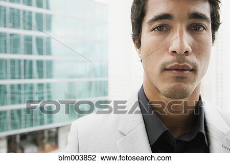 Stock Image - Close up of Hispanic businessman looking serious. Fotosearch