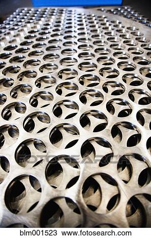 Stock Image - Close up of metal punched with holes. Fotosearch