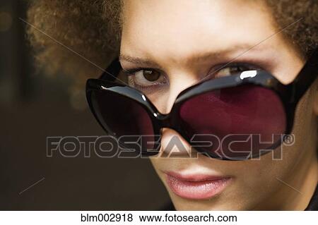 Close up of mixed race woman wearing sunglasses View Large Photo Image Stock Photo - Close up of mixed race woman wearing sunglasses. Fotosearch