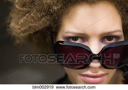 Stock Photo - Close up of mixed race woman wearing sunglasses. Fotosearch