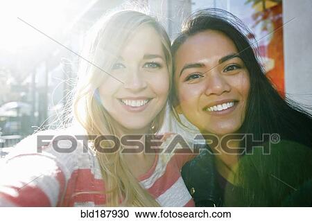 Close up of smiling women hugging outdoors View Large Photo Image Stock Image - Close up of smiling women hugging outdoors. Fotosearch