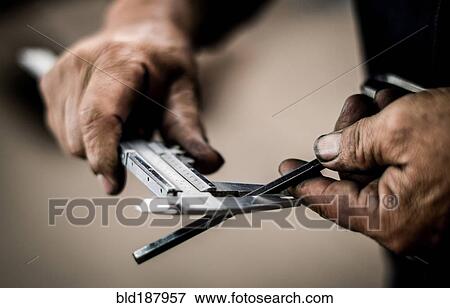 Stock Photo - Close up of worker measuring metal. Fotosearch