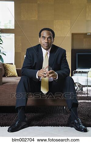 Picture - Confident African businessman sitting in modern living room. Fotosearch