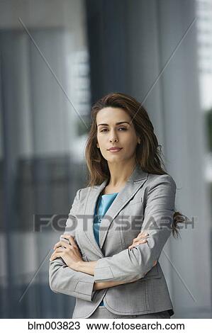Stock Image - Confident Hispanic businesswoman with arms crossed. Fotosearch