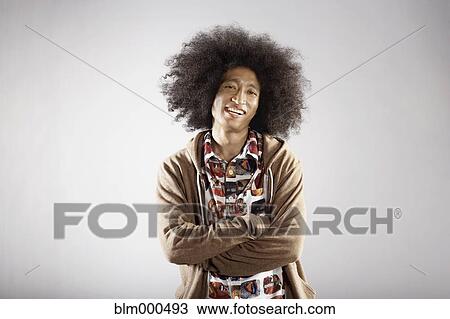 Stock Image - Confident mixed race man with arms crossed. Fotosearch