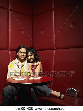 Stock Photo - Couple drinking martinis in nightclub. Fotosearch