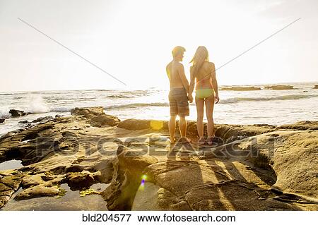 Stock Photo - Couple holding hands on beach. Fotosearch